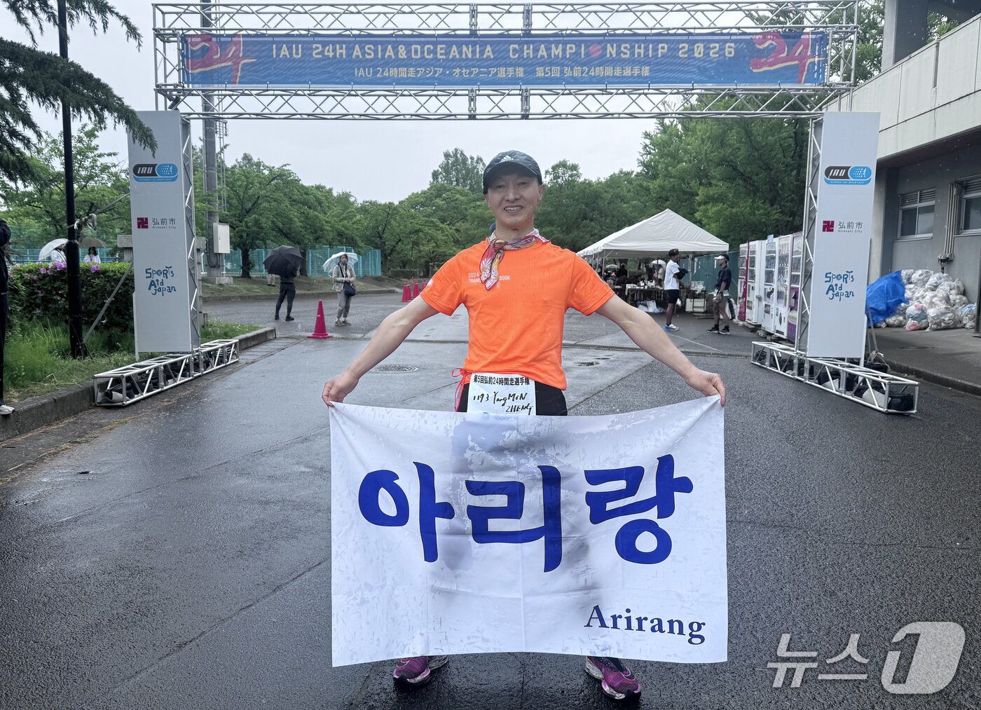 본문 이미지 - 우리나라 참가선수 중 오픈레이스에서 2위를 차지한 중국교포 출신인 정용민 선수가 결승선에서 아리랑 깃발을 들어 보이고 있다. 