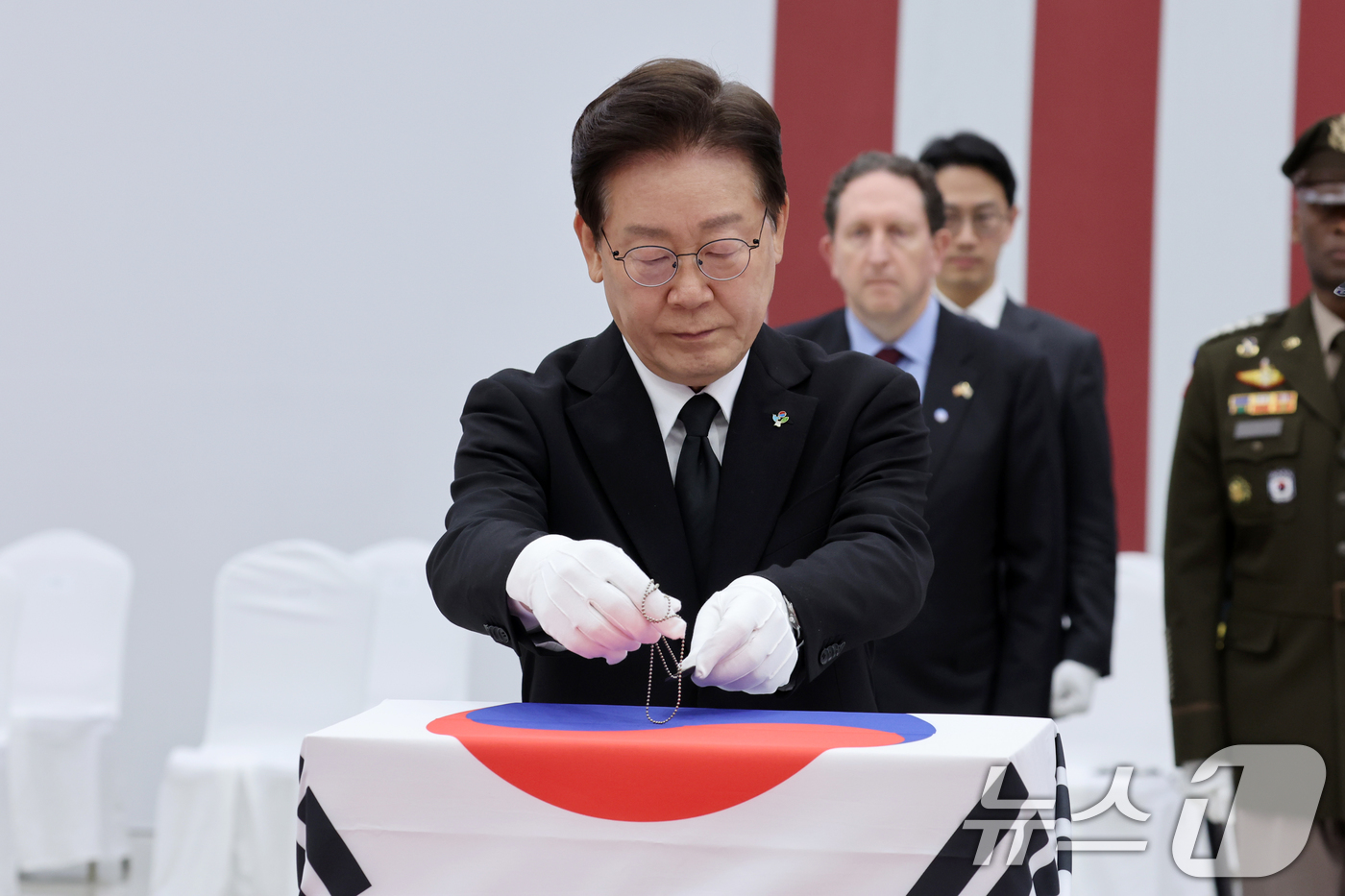 (성남=뉴스1) 이재명 기자 = 이재명 대통령이 5일 경기 성남시 서울공항에서 열린 한미 6·25전사자 유해 상호봉환식에서 전사자 유해에 무명 군번줄을 수여하고 있다. 2026.6 …