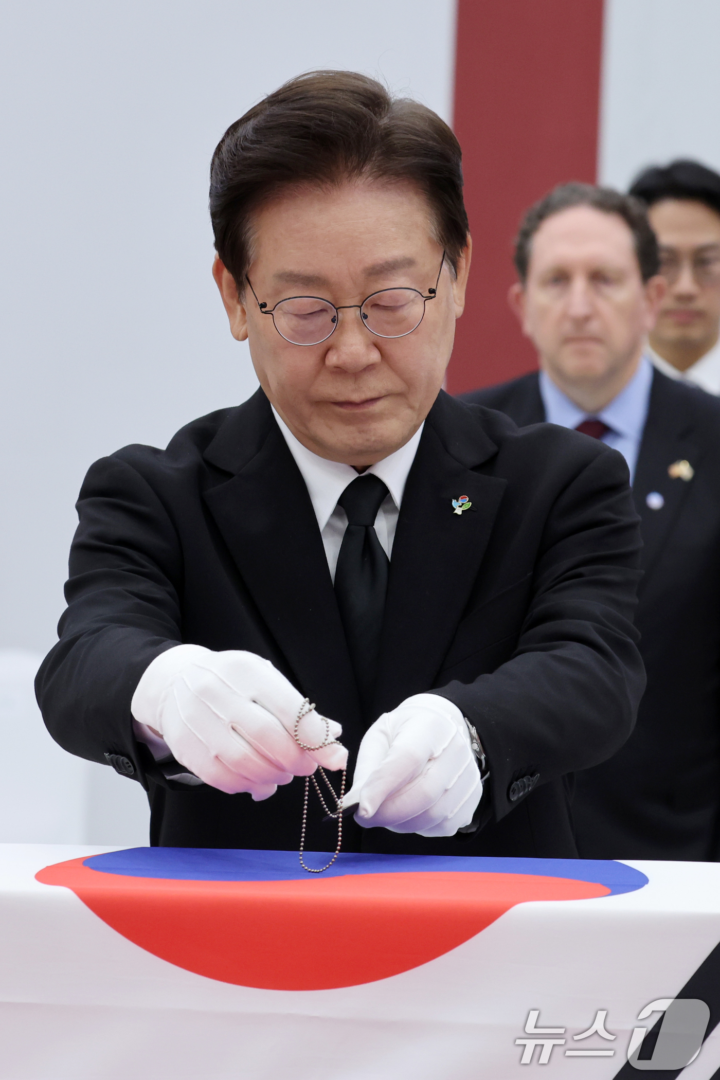(성남=뉴스1) 이재명 기자 = 이재명 대통령이 5일 경기 성남시 서울공항에서 열린 한미 6·25전사자 유해 상호봉환식에서 전사자 유해에 무명 군번줄을 수여하고 있다. 2026.6 …