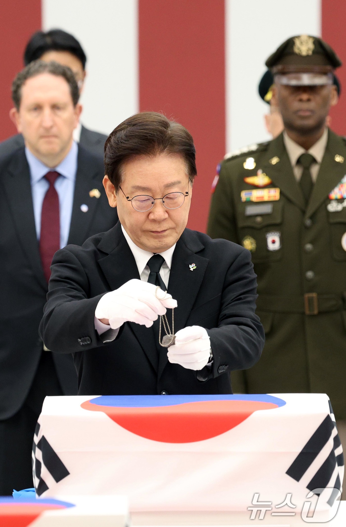 (성남=뉴스1) 이재명 기자 = 이재명 대통령이 5일 경기 성남시 서울공항에서 열린 한미 6·25전사자 유해 상호봉환식에서 전사자 유해에 무명 군번줄을 수여하고 있다. 2026.6 …