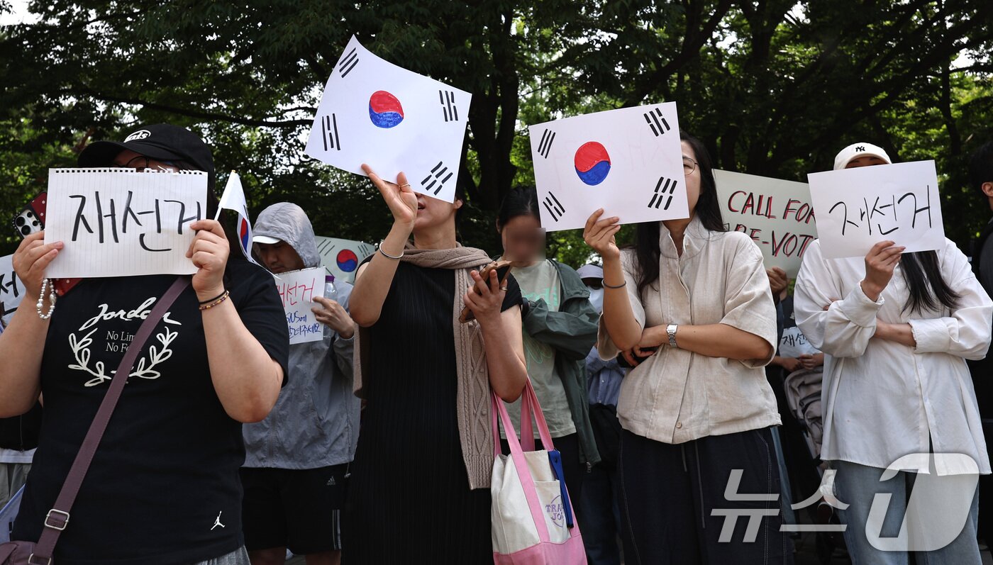 본문 이미지 - 6·3 지방선거 투표용지 부족 사태에 반발한 시민들이 6일 오전 서울 송파구 올림픽공원 핸드볼경기장 개표소 앞에 모여 재선거를 요구하는 구호를 외치고 있다. 2026.6.6 ⓒ 뉴스1 구윤성 기자