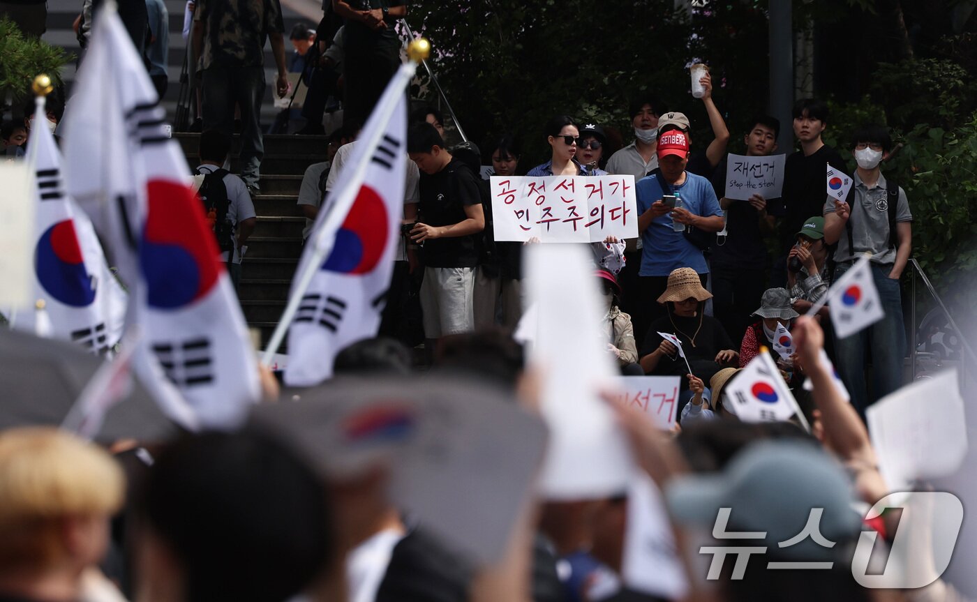 본문 이미지 - 6·3 지방선거 투표용지 부족 사태에 반발한 시민들이 6일 오전 서울 송파구 올림픽공원 핸드볼경기장 개표소 앞에 모여 재선거를 요구하는 구호를 외치고 있다. 2026.6.6 ⓒ 뉴스1 구윤성 기자