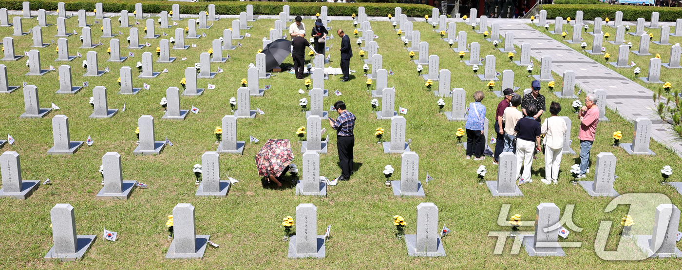 (전주=뉴스1) 유경석 기자 = 현충일인 6일 전북 전주시 군경묘지를 찾은 추모객들이 참배를 하고 있다. 2026.6.6/뉴스1
