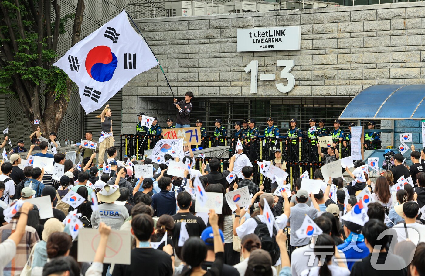 본문 이미지 - 제9회 전국동시지방선거 투표용지 부족 사태에 반발한 시민들이 7일 서울 송파구 올림픽공원 핸드볼경기장 개표소 앞에 모여 재선거를 요구하는 구호를 외치고 있다. 2026.6.7 ⓒ 뉴스1 이호윤 기자
