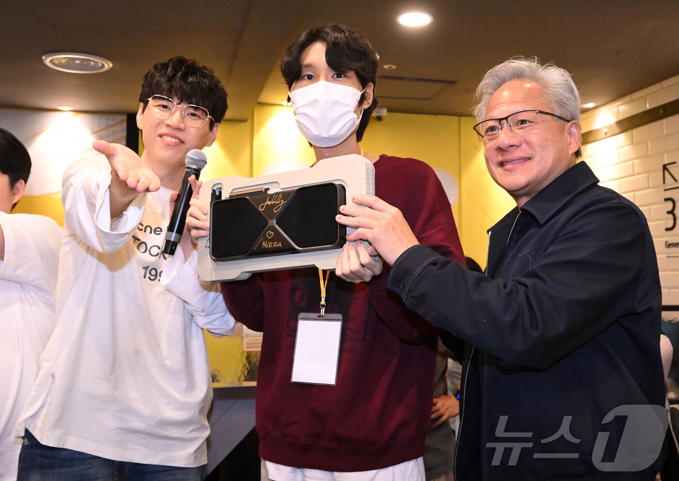 본문 이미지 - 젠슨 황 엔비디아 최고경영자(CEO)가 7일 서울 강남구 옵티멈존 PC카페에서 추첨을 통해 선정된 크래프톤 유저에게 최신 그래픽카드 '지포스RTX5090'를 선물하고 있다. (공동취재) 2026.6.7 ⓒ 뉴스1 김진환 기자