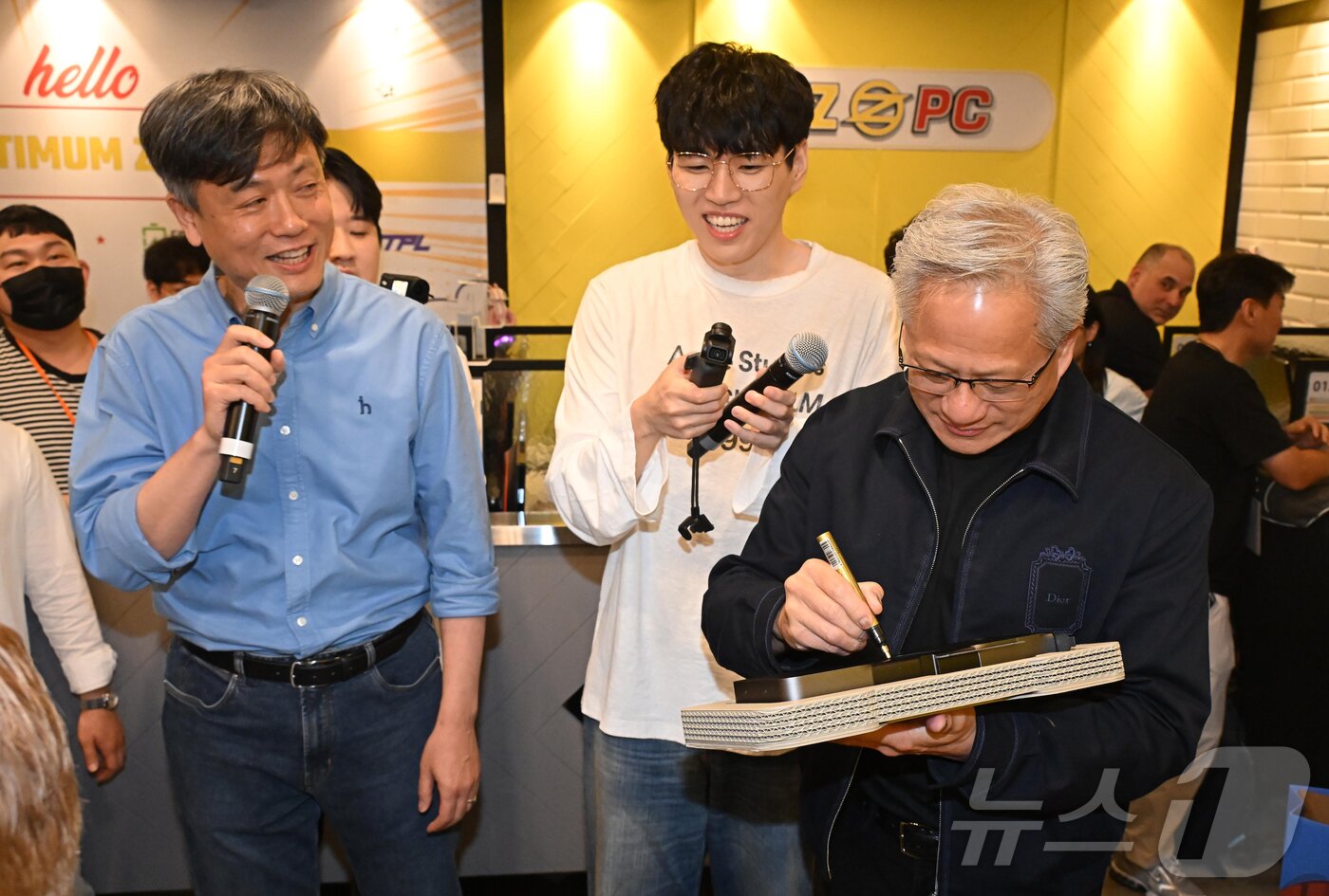 본문 이미지 - 젠슨 황 엔비디아 최고경영자(CEO)가 7일 서울 강남구 옵티멈존 PC카페에서 크래프톤 유저에게 선물할 최신 그래픽카드 '지포스RTX5090'에 사인하고 있다. (공동취재) 2026.6.7 ⓒ 뉴스1 김진환 기자