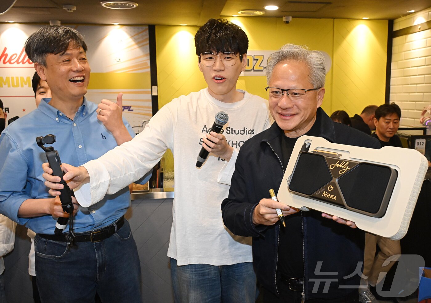 본문 이미지 - 젠슨 황 엔비디아 최고경영자(CEO)가 7일 서울 강남구 옵티멈존 PC카페에서 크래프톤 유저에게 선물할 최신 그래픽카드 '지포스RTX5090'에 사인하고 있다. (공동취재) 2026.6.7 ⓒ 뉴스1 김진환 기자