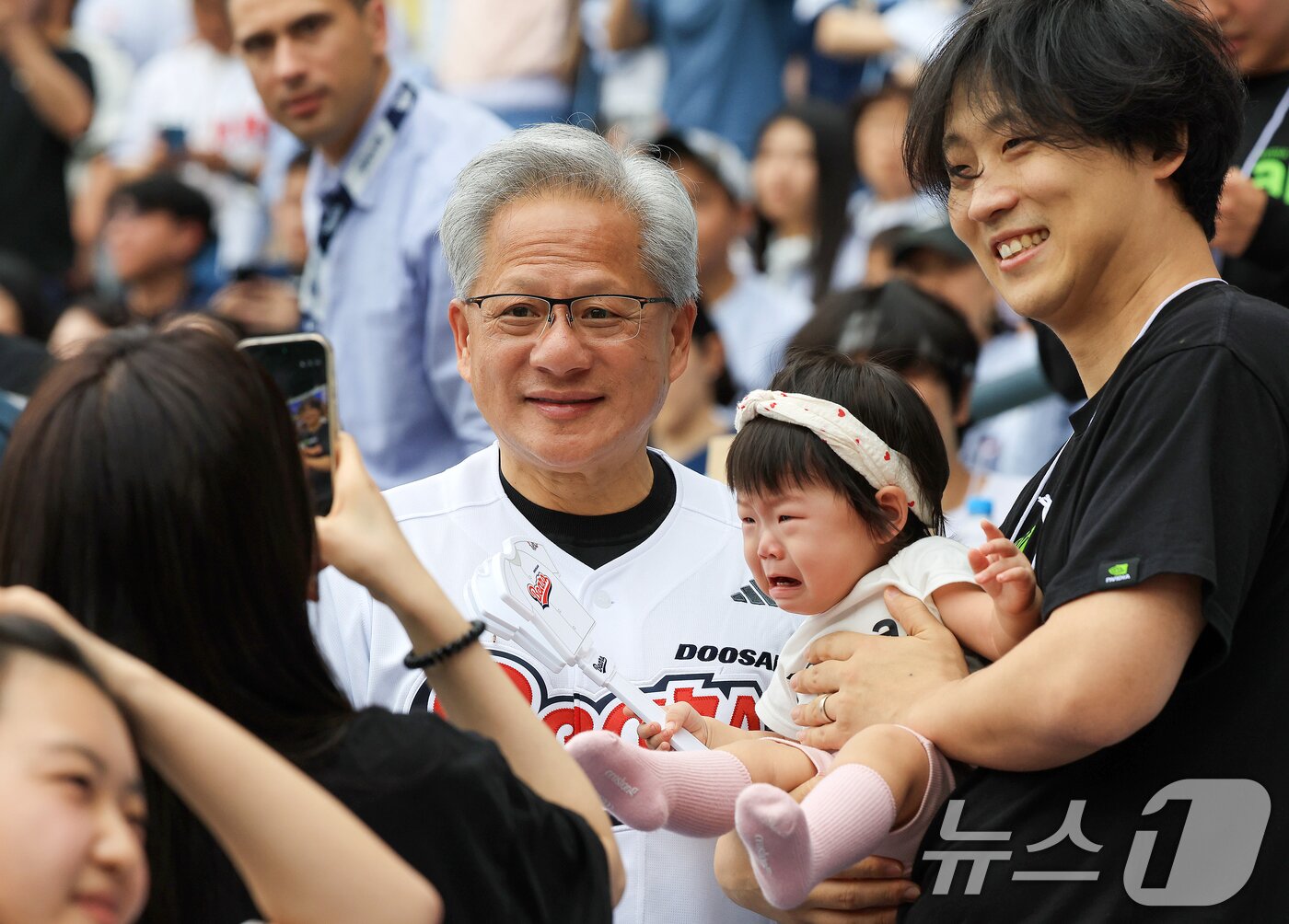 본문 이미지 - 젠슨 황 엔비디아 최고경영자(CEO)가 7일 서울 송파구 잠실야구장에서 열린 프로야구 '2026 신한은행 SOL KBO리그' 키움 히어로즈와 두산 베어스의 경기를 찾아 팬들과 기념사진을 찍고 있다. 2026.6.7 ⓒ 뉴스1 이호윤 기자