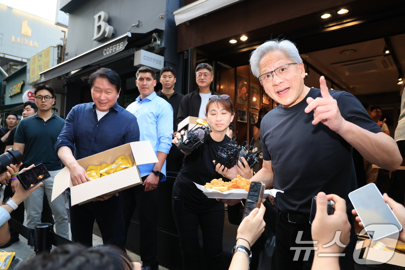 (서울=뉴스1) 이호윤 기자 = 젠슨 황 엔비디아 최고경영자(CEO)와 최태원 SK그룹 회장이 7일 오후 서울 강남구 깐부치킨 삼성점에서 '치맥 회동' 중 시민 및 취재진에게 치킨 …