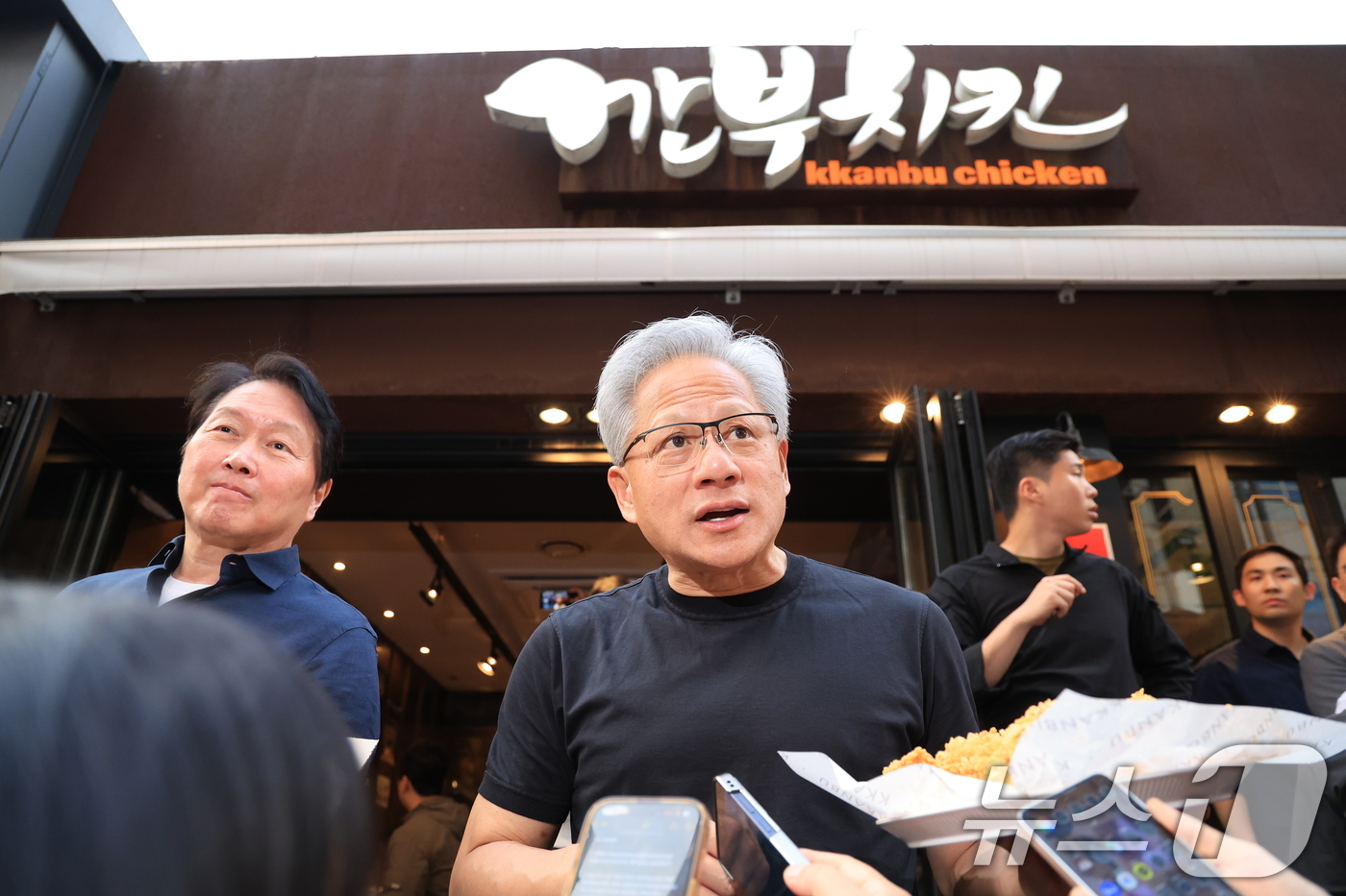 (서울=뉴스1) 이호윤 기자 = 젠슨 황 엔비디아 최고경영자(CEO)가 7일 오후 서울 강남구 깐부치킨 삼성점에서 최태원 SK그룹 회장과 '치맥 회동' 중 시민 및 취재진에게 치킨 …