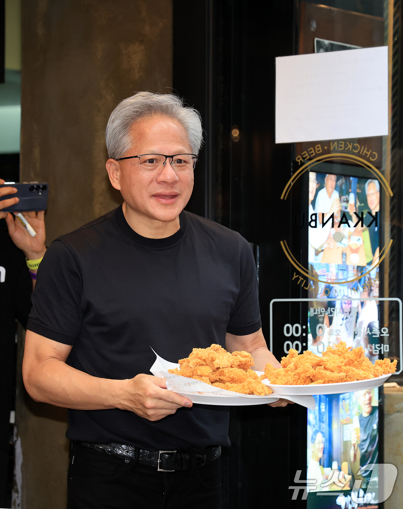 (서울=뉴스1) 이호윤 기자 = 젠슨 황 엔비디아 최고경영자(CEO)가 7일 오후 서울 강남구 깐부치킨 삼성점에서 최태원 SK그룹 회장과 '치맥 회동' 중 시민 및 취재진에게 치킨 …