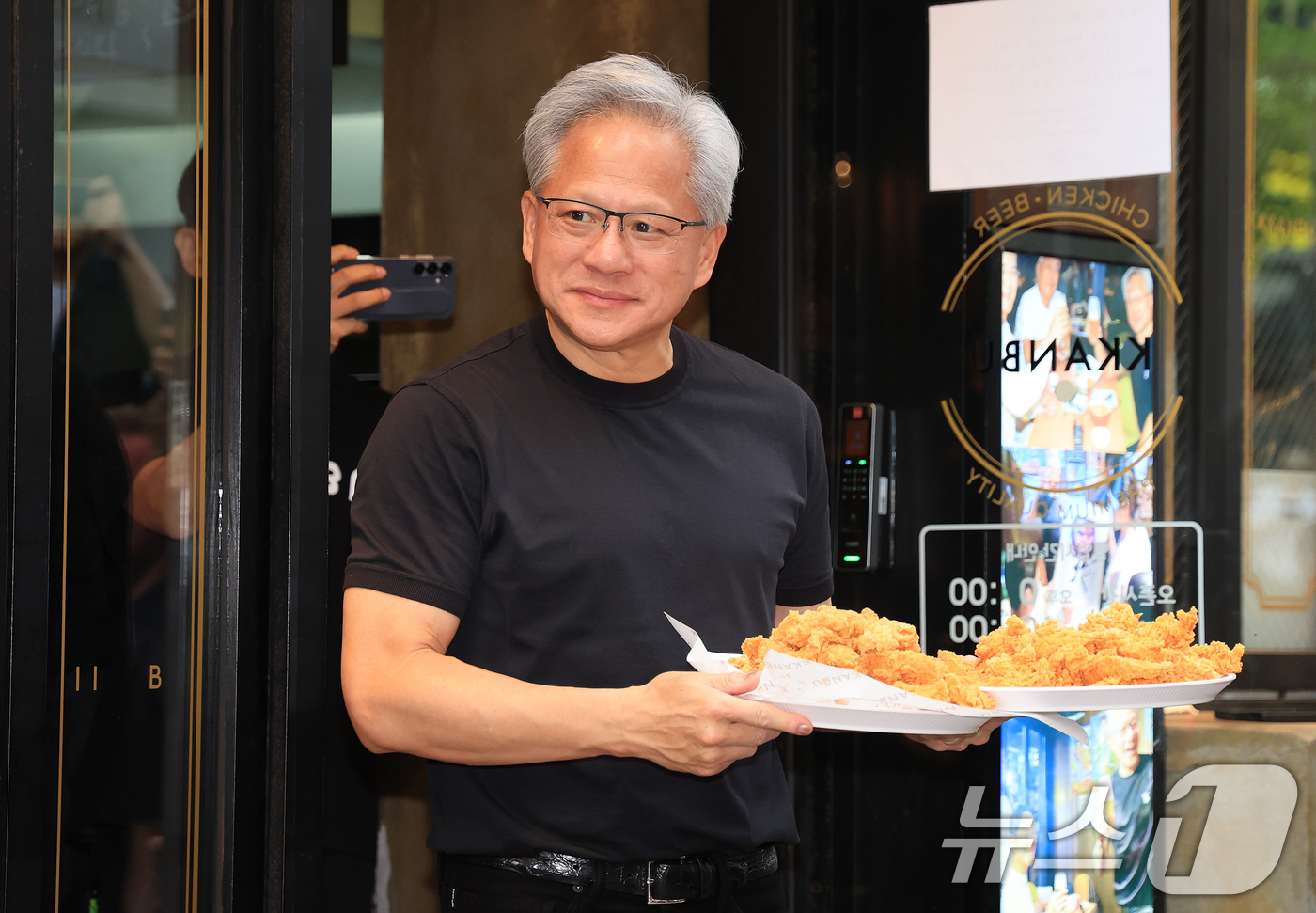 (서울=뉴스1) 이호윤 기자 = 젠슨 황 엔비디아 최고경영자(CEO)가 7일 오후 서울 강남구 깐부치킨 삼성점에서 최태원 SK그룹 회장과 '치맥 회동' 중 시민 및 취재진에게 치킨 …