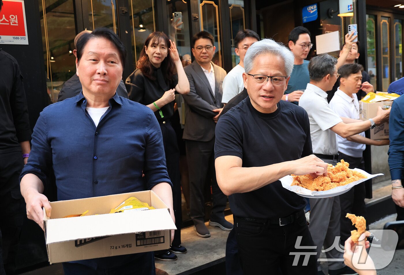 본문 이미지 - 젠슨 황 엔비디아 최고경영자(CEO)와 최태원 SK그룹 회장이 7일 오후 서울 강남구 깐부치킨 삼성점에서 '치맥 회동' 중 시민 및 취재진에게 치킨과 간식을 나눠주고 있다. 2026.6.7 ⓒ 뉴스1 이호윤 기자