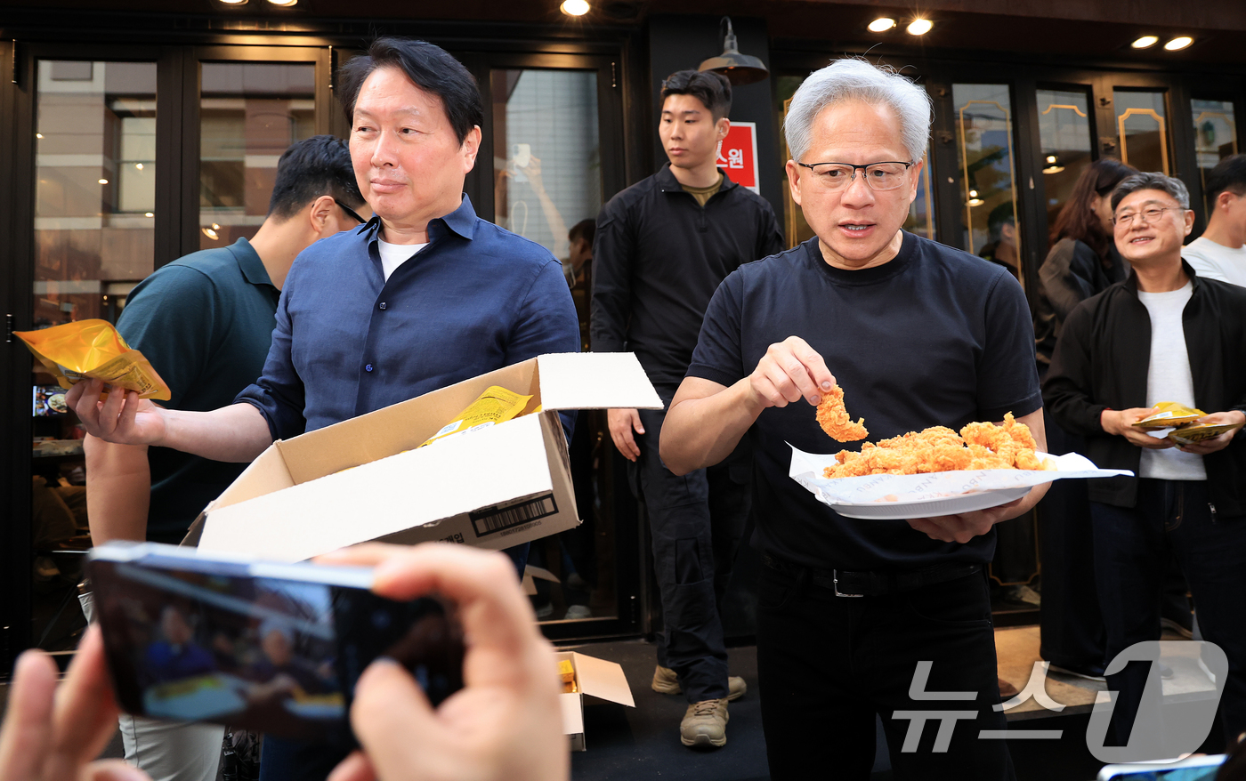 (서울=뉴스1) 이호윤 기자 = 젠슨 황 엔비디아 최고경영자(CEO)와 최태원 SK그룹 회장이 7일 오후 서울 강남구 깐부치킨 삼성점에서 '치맥 회동' 중 시민 및 취재진에게 치킨 …