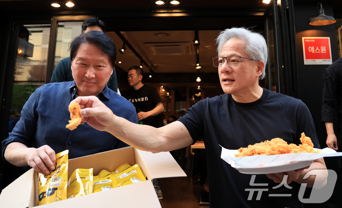 (서울=뉴스1) 이호윤 기자 = 젠슨 황 엔비디아 최고경영자(CEO)와 최태원 SK그룹 회장이 7일 오후 서울 강남구 깐부치킨 삼성점에서 '치맥 회동' 중 시민 및 취재진에게 치킨 …