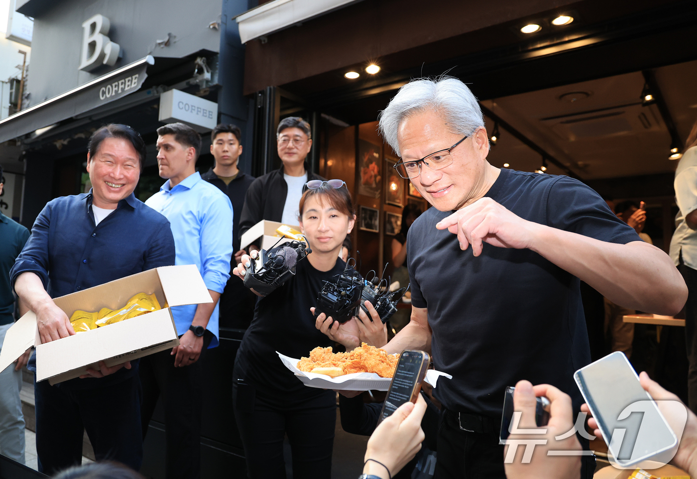 (서울=뉴스1) 이호윤 기자 = 젠슨 황 엔비디아 최고경영자(CEO)와 최태원 SK그룹 회장이 7일 오후 서울 강남구 깐부치킨 삼성점에서 '치맥 회동' 중 시민 및 취재진에게 치킨 …