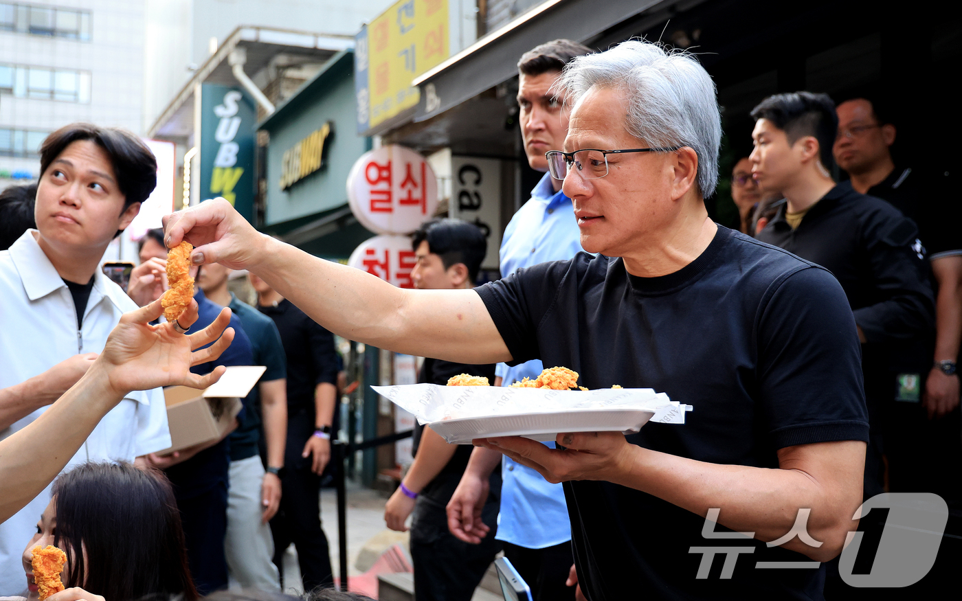 (서울=뉴스1) 이호윤 기자 = 젠슨 황 엔비디아 최고경영자(CEO)와 최태원 SK그룹 회장이 7일 오후 서울 강남구 깐부치킨 삼성점에서 '치맥 회동' 중 시민 및 취재진에게 치킨 …