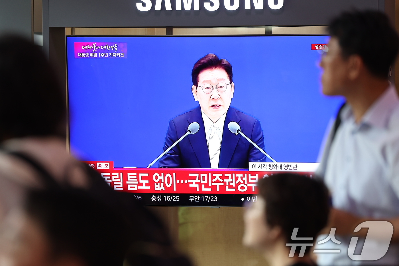 (서울=뉴스1) 김성진 기자 = 8일 오전 서울역 대합실에서 이재명 대통령의 취임 1주년 기자회견 생방송이 나오고 있다. 2026.6.8/뉴스1