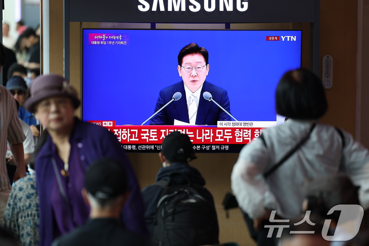 (서울=뉴스1) 김성진 기자 = 8일 오전 서울역 대합실에서 이재명 대통령의 취임 1주년 기자회견 생방송이 나오고 있다. 2026.6.8/뉴스1