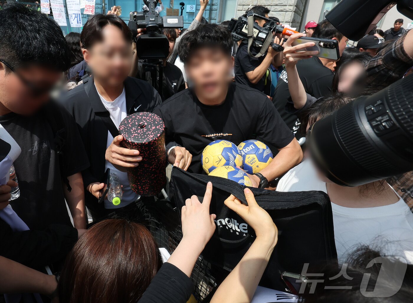본문 이미지 - 제9회 전국동시지방선거 투표용지 부족 사태를 규탄하는 집회가 계속되고 있는 8일 재선거를 요구하는 시민들이 서울 송파구 올림픽공원 핸드볼경기장을 나온 핸드볼 주니어 대표팀 관계자의 물품을 확인하고 있다. 2026.6.8 ⓒ 뉴스1 김진환 기자
