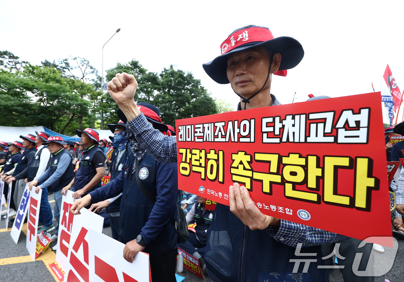 (서울=뉴스1) 김민지 기자 = 전국레미콘운송노동조합 조합원들이 8일 오전 서울 여의도공원 인근에서 운반비 인상과 임금·단체협약 체결을 촉구하는 결의대회를 갖고 구호를 외치고 있다 …