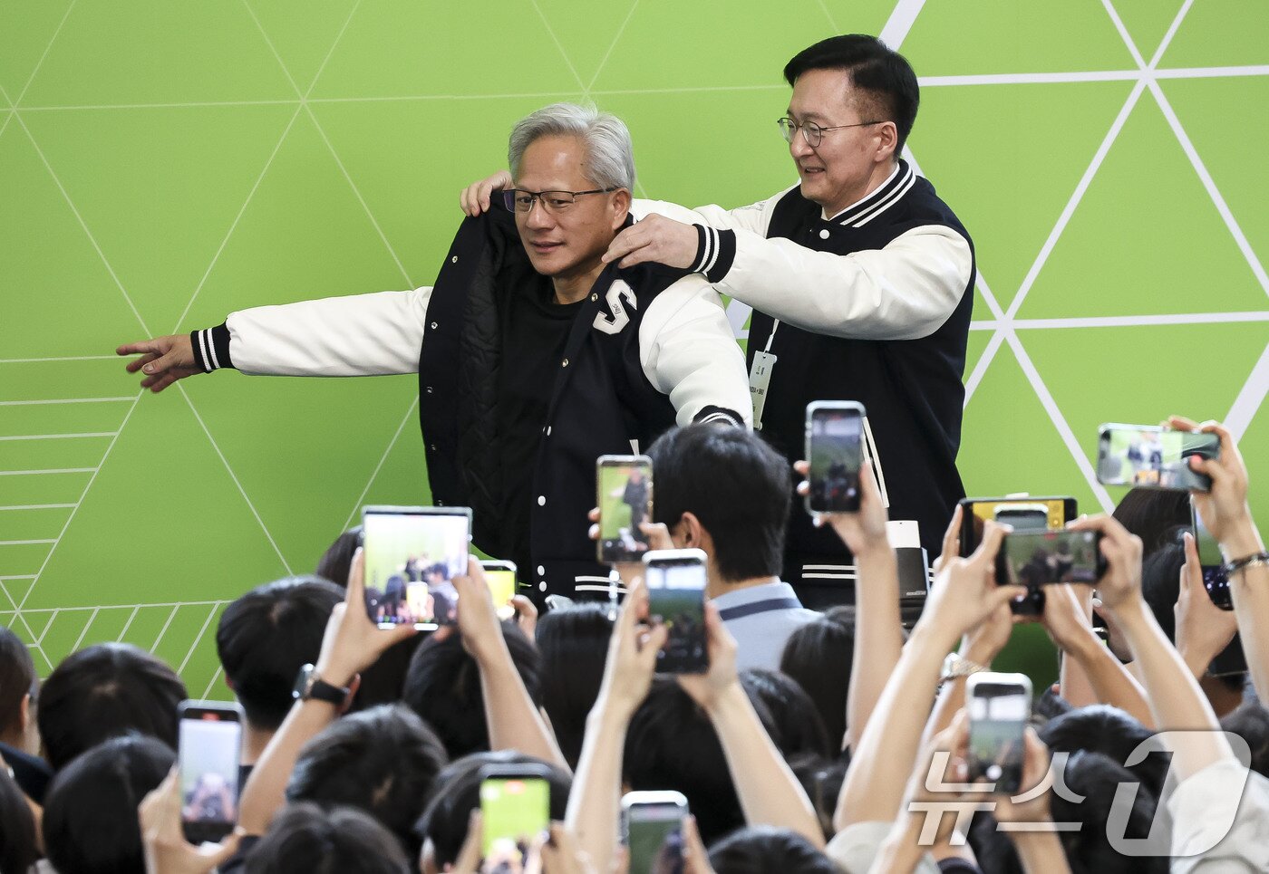 본문 이미지 - 젠슨 황 엔비디아 최고경영자(CEO)가 8일 서울대학교 해동첨단공학관에서 열린 '빌드어클로(Build-a-Claw)' 행사장에서 유홍림 서울대 총장으로부터 학교 점퍼를 선물받고 있다. (공동취재) 2026.6.8 ⓒ 뉴스1 이광호 기자