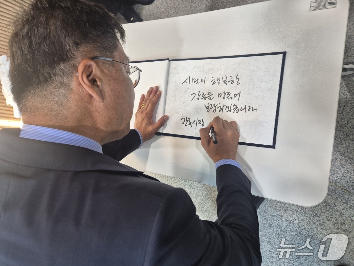 본문 이미지 - 김중남 민선 9기 강원 강릉시장 당선인이 8일 강릉워케이션센터 2층에서 열린 시장직 인수위원회 출범식에서 방명록에 '시민이 행복한 강릉을 만들어 보답하겠습니다'라는 각오를 적고 있다. 2026.6.8/뉴스1 윤왕근 기자