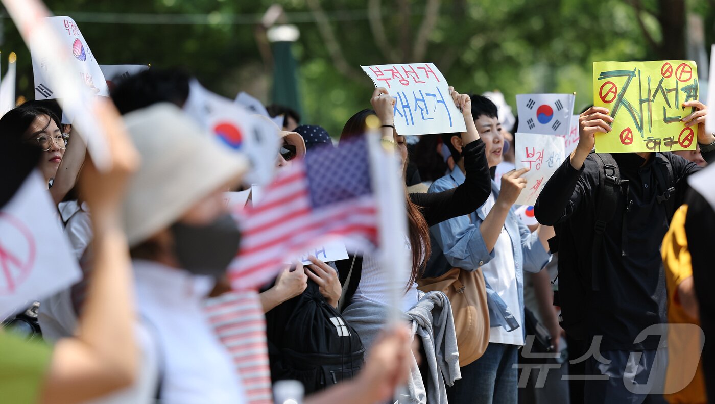 본문 이미지 - 제9회 전국동시지방선거 투표용지 부족 사태에 반발한 시민들이 9일 서울 송파구 올림픽공원 핸드볼경기장에 설치된 개표소 앞에서 재선거를 촉구하며 구호를 외치고 있다. 2026.6.9 ⓒ 뉴스1 김성진 기자