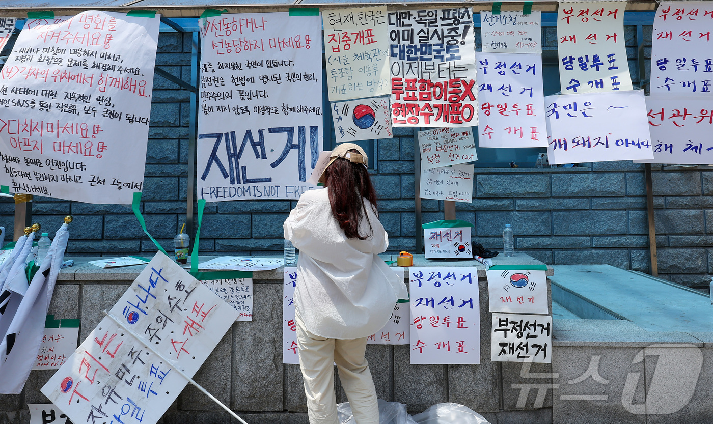 (서울=뉴스1) 김성진 기자 = 제9회 전국동시지방선거 투표용지 부족 사태에 반발한 시민들이 9일 서울 송파구 올림픽공원 핸드볼경기장에 설치된 개표소 앞에서 재선거를 촉구하며 피켓 …