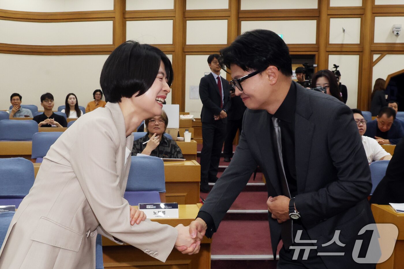 본문 이미지 - 한동훈 무소속 의원과 한지아 국민의힘 의원이 지난 7월 1일 오전 서울 여의도 국회 의원회관에서 열린 '국민통합컨센서스 대화 2026'에서 악수를 나누고 있다. 2026.7.1 ⓒ 뉴스1 황기선 기자