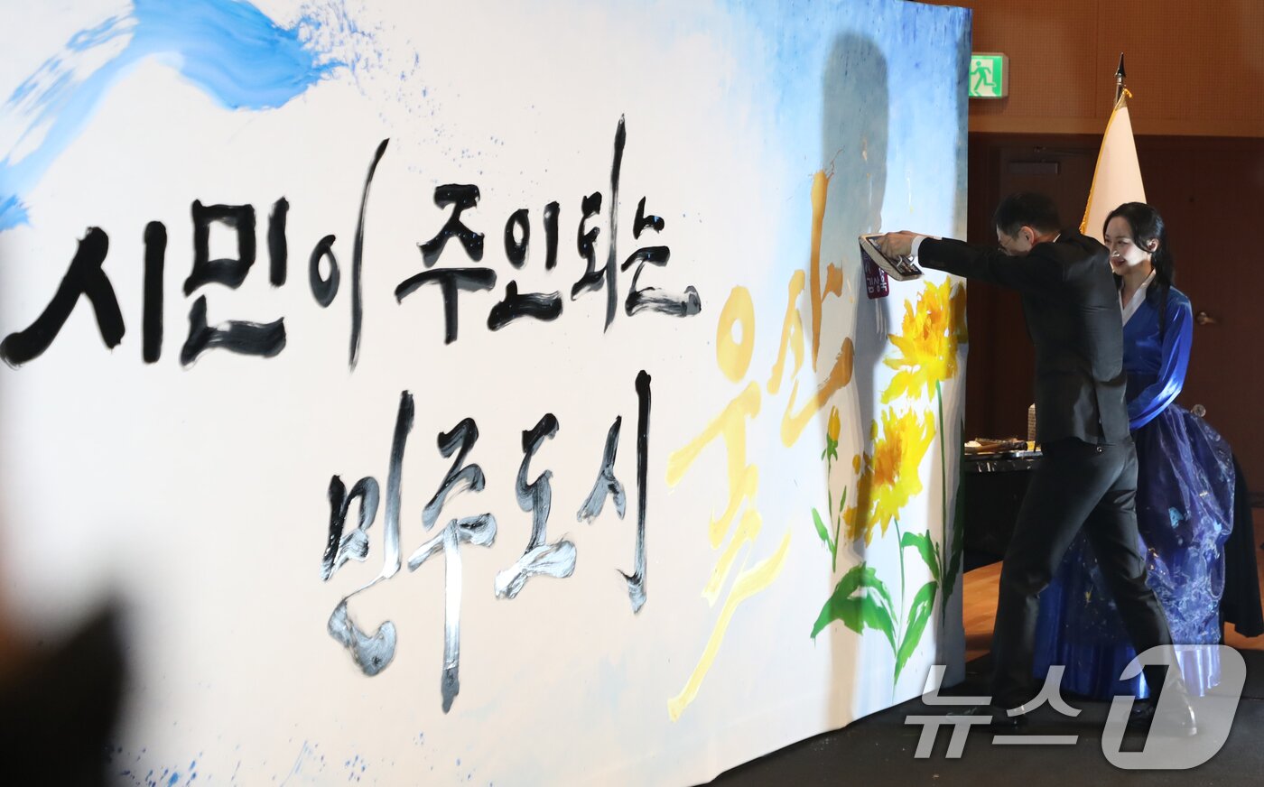 본문 이미지 - 김상욱 울산시장이 1일 오전 울산시청 대강당에서 열린 제9대 울산광역시장 취임식에서 '시민이 주인되는 민주도시 울산'이라고 적힌 캘리그래피 작품에 시장 직인을 찍고 있다. 2026.7.1 ⓒ 뉴스1 조민주 기자