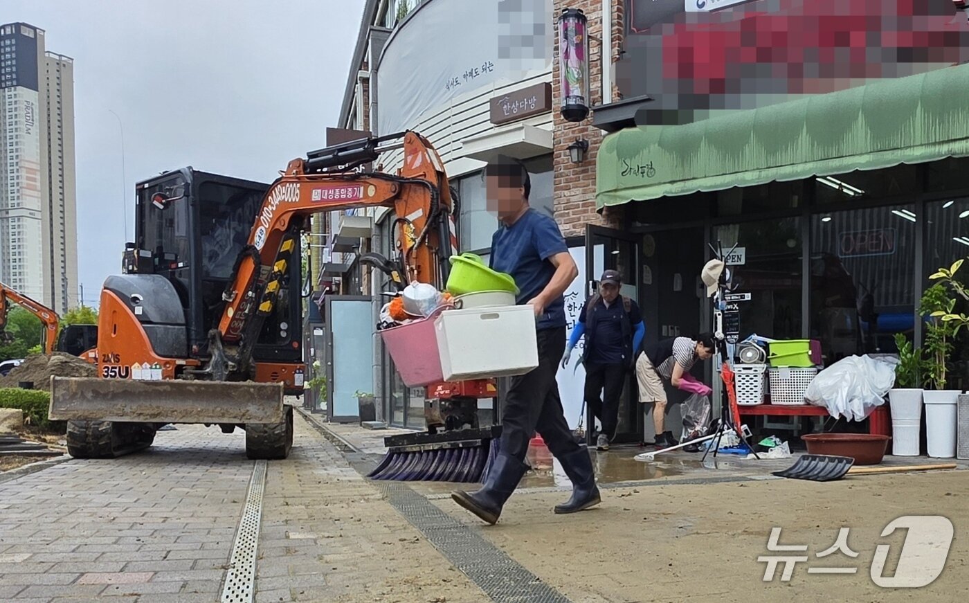 본문 이미지 - 10일 상수도관 누수로 침수피해가 발생한 천안의 한 아파트 상가 주민들이 물에 젖은 집기류 등을 정리하고 있다. 2026.7.10. ⓒ 뉴스1 이시우 기자