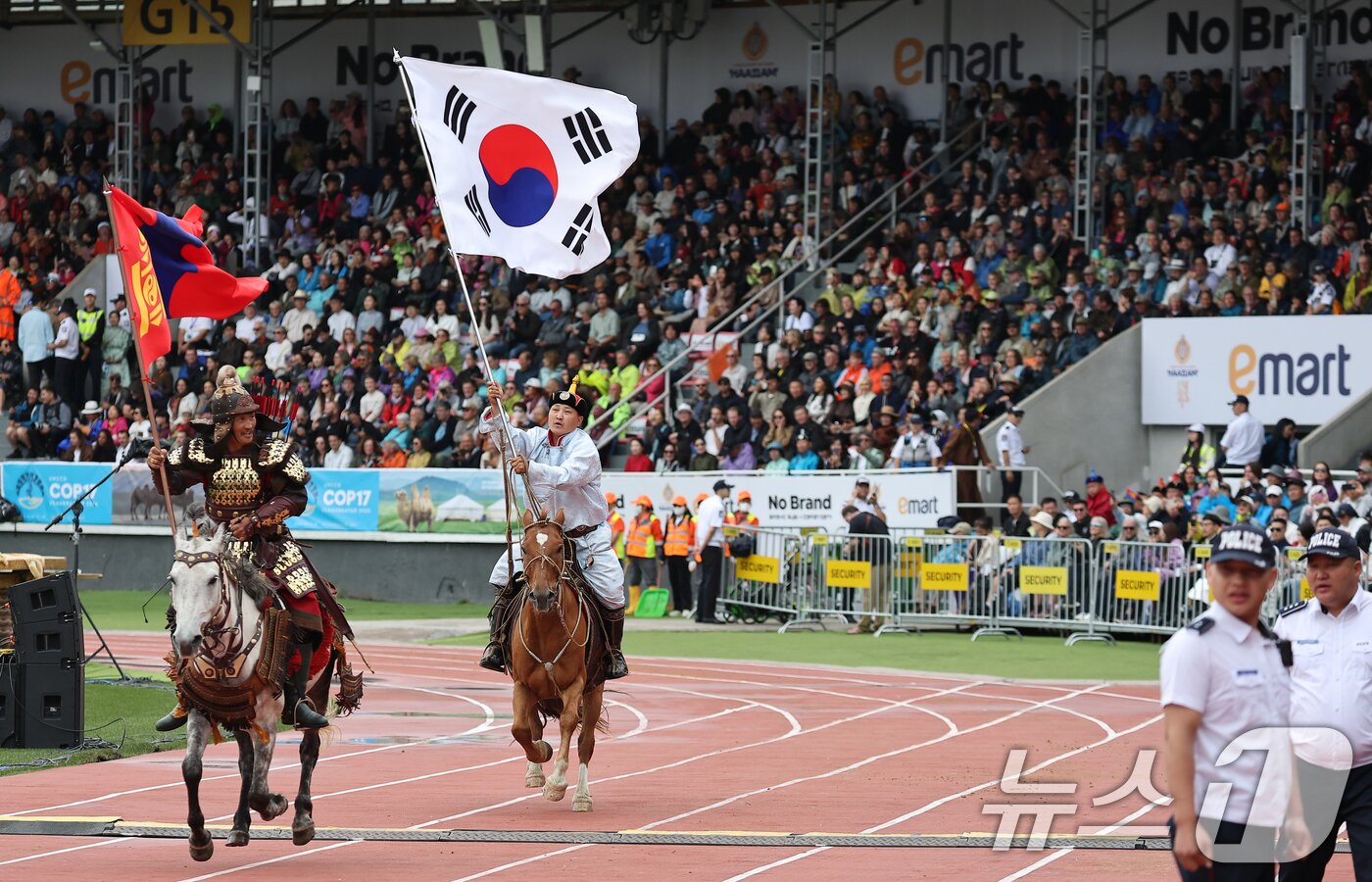 본문 이미지 - 11일(현지시간) 몽골 울란바타르 국립 체육경기장에서 열린 나담축제 개막식에서 태극기를 든 공연 참가자가 말을 타고 질주하고 있다. 이재명 대통령은 이날 몽골의 자유와 독립정신을 기리는 최대 명절인 '나담축제'에 공식 주빈으로 참석했다. 2026.7.11 ⓒ 뉴스1 이재명 기자