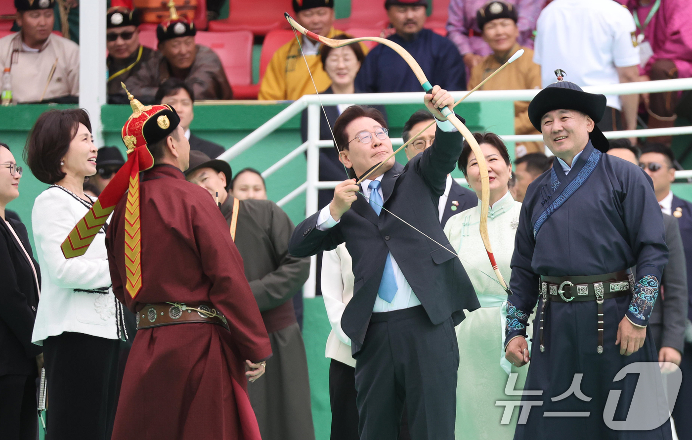 (울란바타르(몽골))=뉴스1) 이재명 기자 = 몽골을 국빈 방문 중인 이재명 대통령이 11일(현지시간) 울란바타르 나담축제장에서 전통활쏘기를 체험하고 있다. 오른쪽은 오흐나 후렐수 …