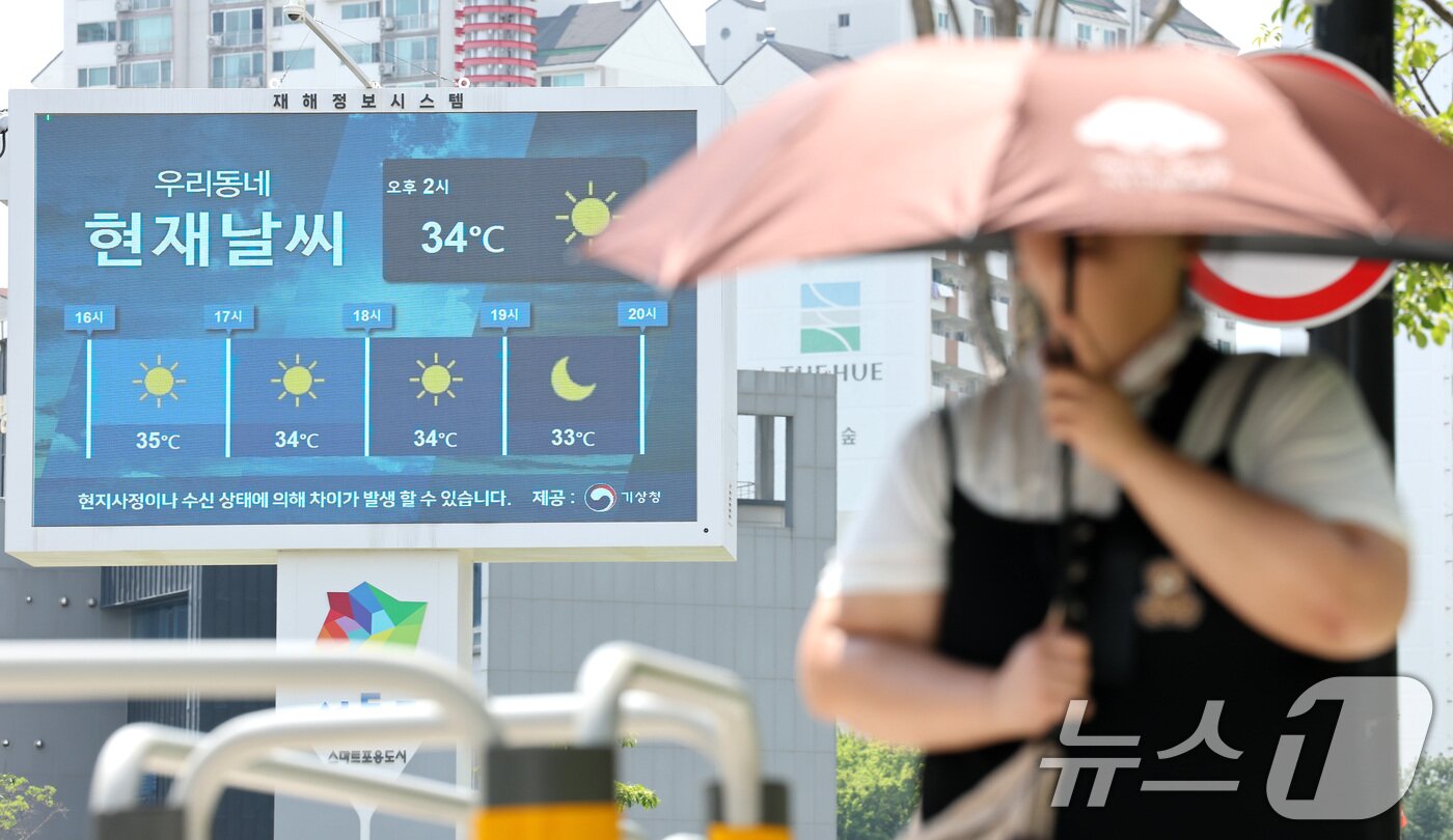 본문 이미지 - 서울 낮 최고기온이 34도로 무더운 날씨를 보인 12일 오후 서울 시내에 설치된 재해정보시스템 전광판에 현재 기온이 표시되고 있다. 2026.7.12 ⓒ 뉴스1 임세영 기자