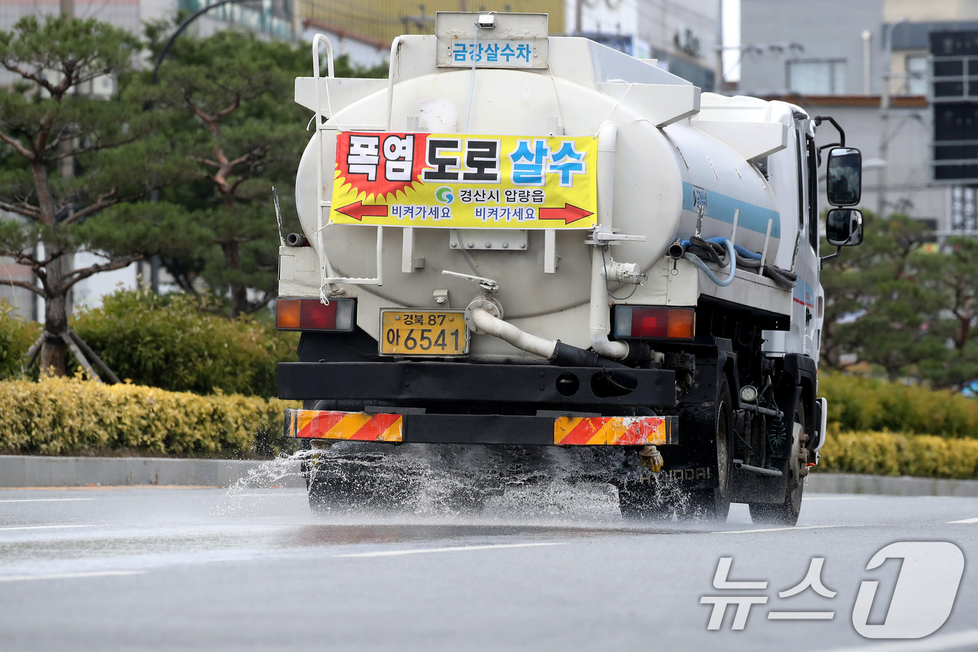 (경산=뉴스1) 공정식 기자 = 경북 경산과 포항에 사상 첫 '폭염중대경보'가 발령된 12일 오후 영남대 경산캠퍼스 앞 도로에서 살수차가 뜨거워진 아스팔트를 식히기 위해 물을 뿌리 …