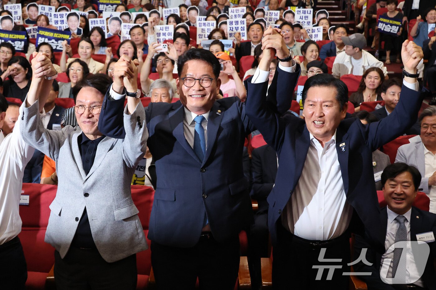 본문 이미지 - 김민석(왼쪽부터)·송영길·정청래 더불어민주당 당대표 후보가 12일 서울 여의도 국회 의원회관에서 열린 전국자치분권민주지도자회의 당대표 후보 정견 발표에서 손을 잡고 기념 촬영하고 있다. 2026.7.12 ⓒ 뉴스1 신웅수 기자