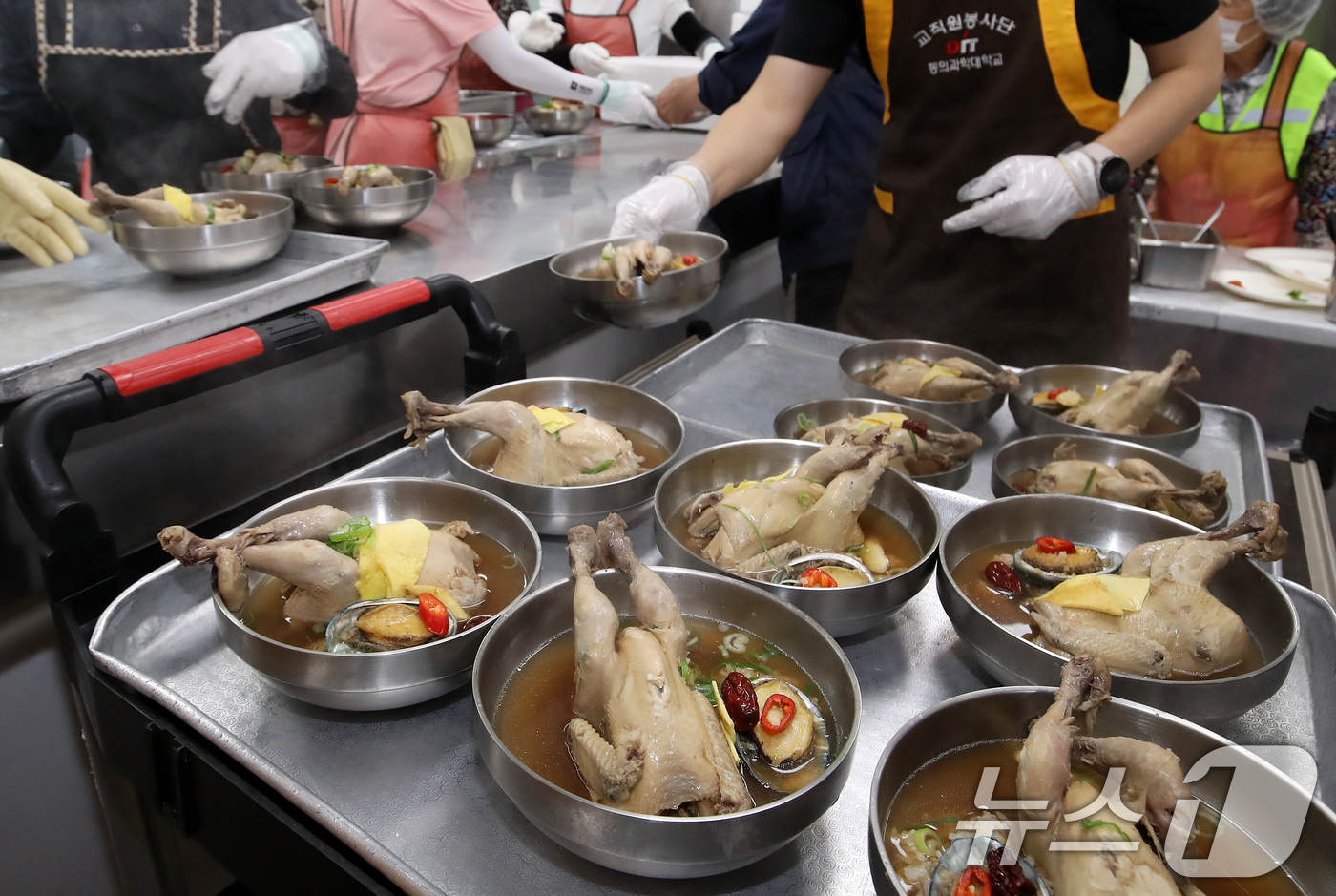 (부산=뉴스1) 윤일지 기자 = 초복을 이틀 앞둔 13일 부산 부산진구노인장애인복지관에서 열린 '제11회 초복맞이 1만그릇 삼계탕 나눔' 행사에서 자원봉사자들이 어르신들에게 삼계탕 …