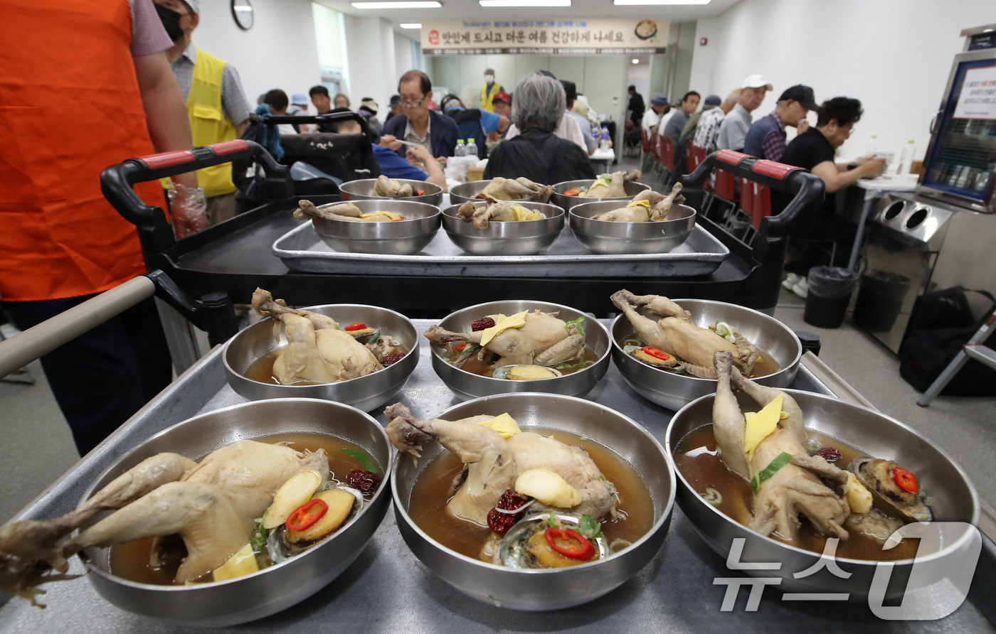 (부산=뉴스1) 윤일지 기자 = 초복을 이틀 앞둔 13일 부산 부산진구노인장애인복지관에서 열린 '제11회 초복맞이 1만그릇 삼계탕 나눔' 행사에서 자원봉사자들이 어르신들에게 삼계탕 …