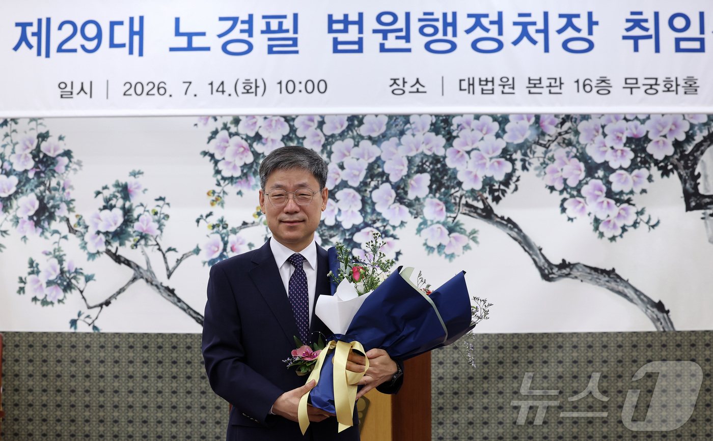 (서울=뉴스1) 김성진 기자 = 노경필 신임 법원행정처장이 14일 서울 서초구 대법원에서 열린 제29대 법원행정처장 취임식에서 축하 꽃다발을 받은 후 기념촬영을 하고 있다. 202 …