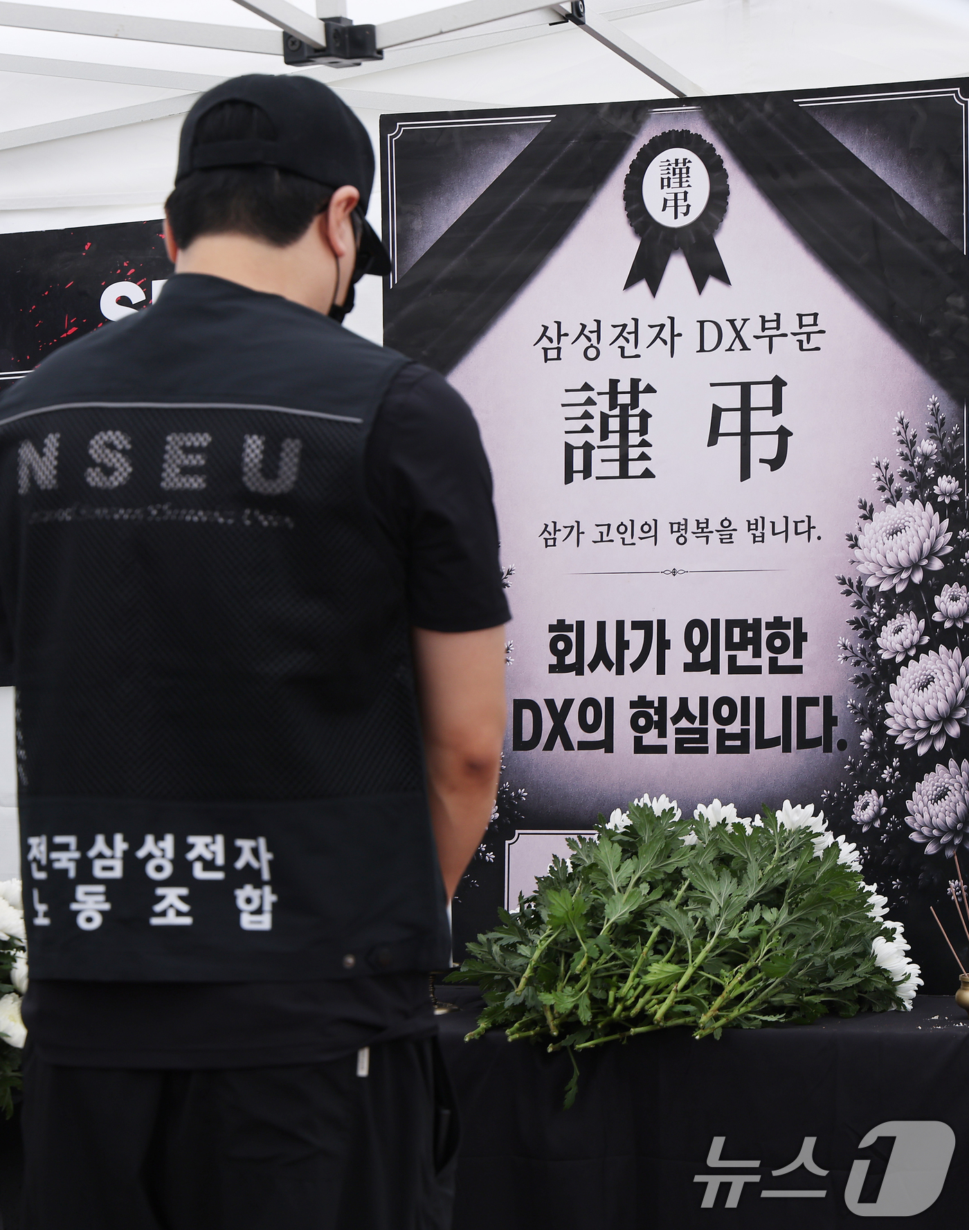 (수원=뉴스1) 김영운 기자 = 14일 경기 수원시 영통구 삼성전자 수원사업장 중앙문에서 열린 'DX부문 사기진작 및 보상마련 촉구 집회'에서 조합원들이 '2026 DX부문 사망선 …
