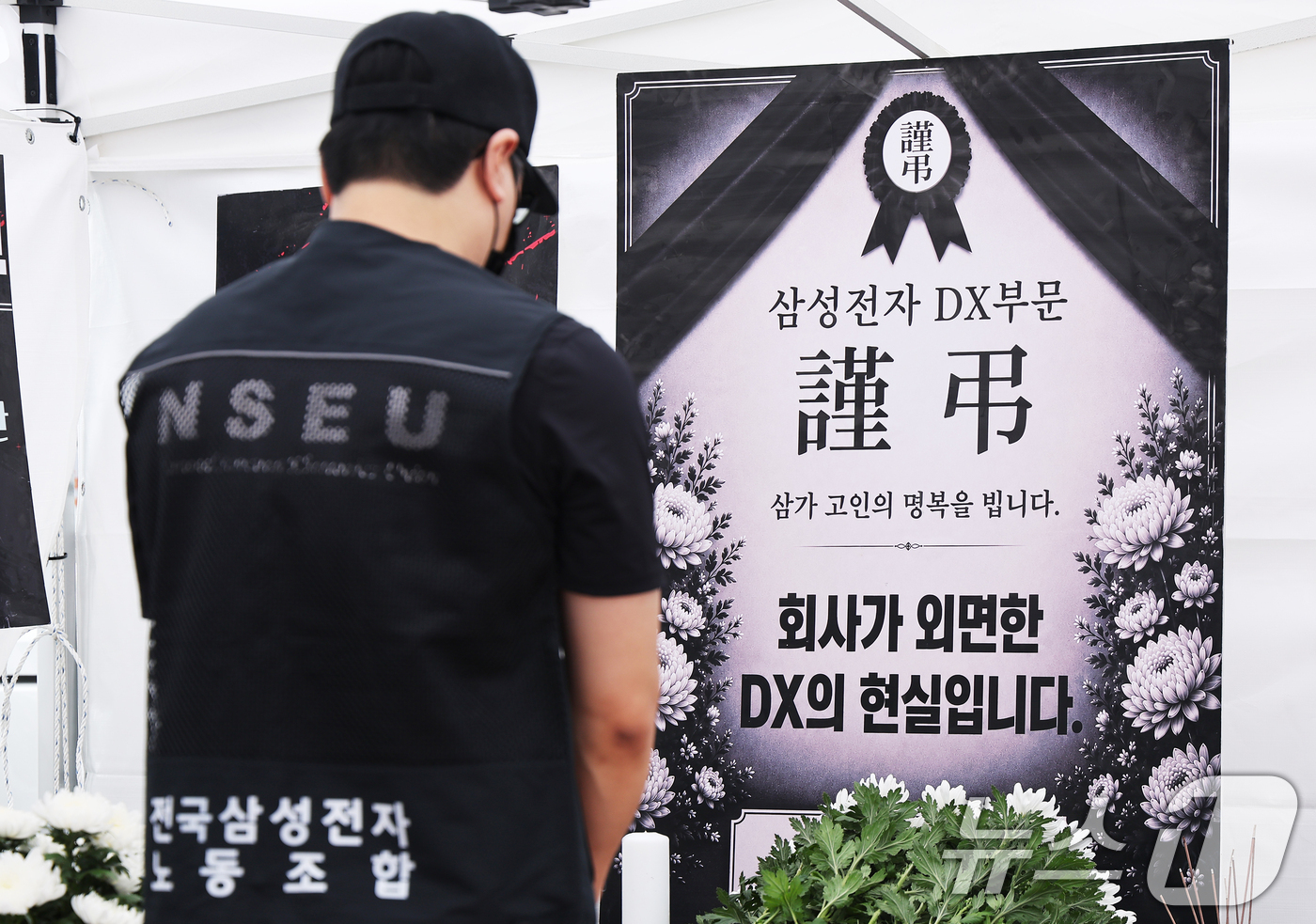 (수원=뉴스1) 김영운 기자 = 14일 경기 수원시 영통구 삼성전자 수원사업장 중앙문에서 열린 'DX부문 사기진작 및 보상마련 촉구 집회'에서 조합원들이 '2026 DX부문 사망선 …