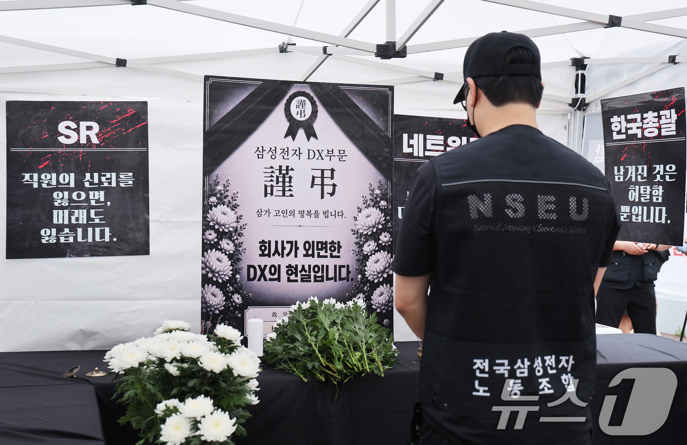(수원=뉴스1) 김영운 기자 = 14일 경기 수원시 영통구 삼성전자 수원사업장 중앙문에서 열린 'DX부문 사기진작 및 보상마련 촉구 집회'에서 조합원들이 '2026 DX부문 사망선 …