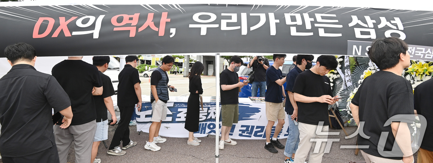 (수원=뉴스1) 김영운 기자 = 14일 경기 수원시 영통구 삼성전자 수원사업장 중앙문에서 열린 'DX부문 사기진작 및 보상마련 촉구 집회'에서 조합원들이 '2026 DX부문 사망선 …
