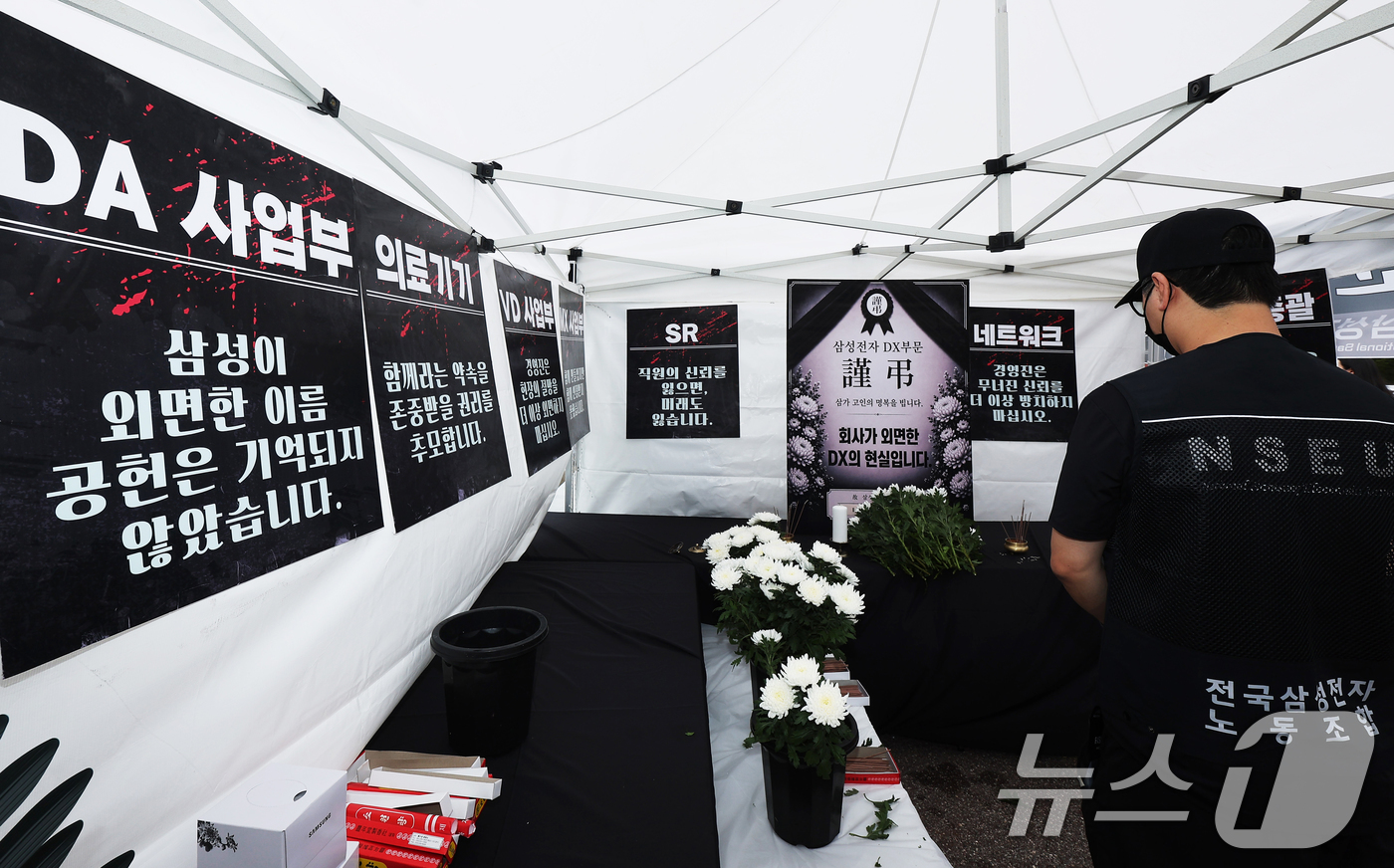 (수원=뉴스1) 김영운 기자 = 14일 경기 수원시 영통구 삼성전자 수원사업장 중앙문에서 열린 'DX부문 사기진작 및 보상마련 촉구 집회'에서 조합원들이 '2026 DX부문 사망선 …