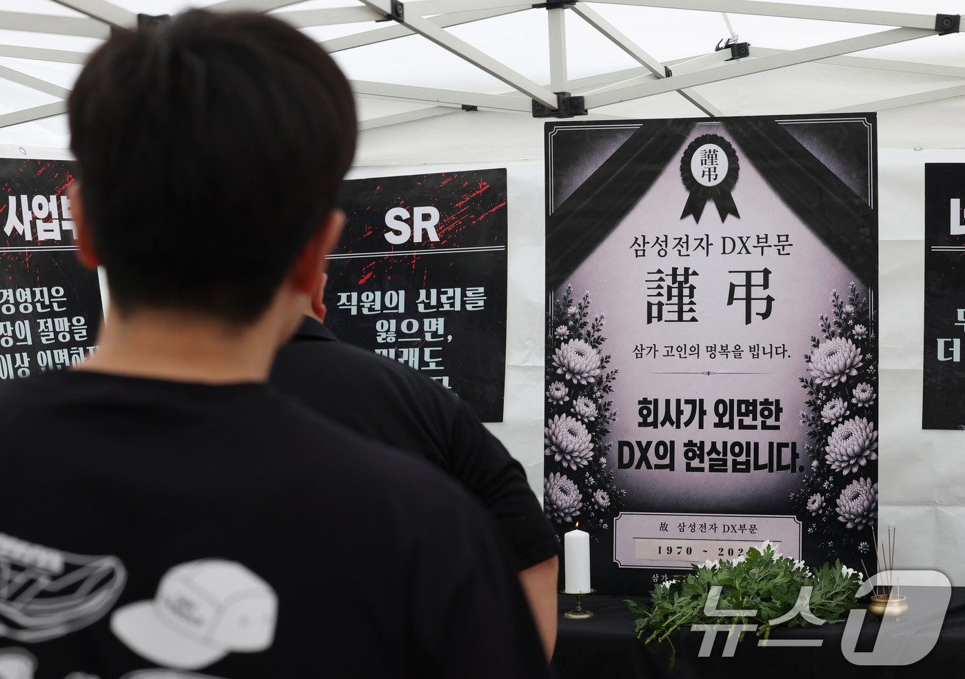 (수원=뉴스1) 김영운 기자 = 14일 경기 수원시 영통구 삼성전자 수원사업장 중앙문에서 열린 'DX부문 사기진작 및 보상마련 촉구 집회'에서 조합원들이 '2026 DX부문 사망선 …