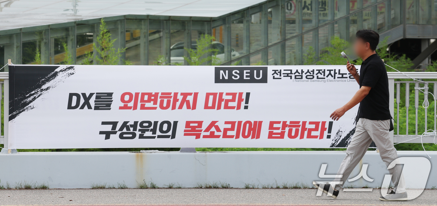 (수원=뉴스1) 김영운 기자 = 14일 경기 수원시 영통구 삼성전자 수원사업장 중앙문에 'DX부문 사기진작 및 보상마련 촉구 집회' 관련 현수막이 붙어있다. 2026.7.14/뉴스 …
