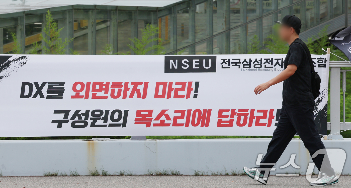 (수원=뉴스1) 김영운 기자 = 14일 경기 수원시 영통구 삼성전자 수원사업장 중앙문에 'DX부문 사기진작 및 보상마련 촉구 집회' 관련 현수막이 붙어있다. 2026.7.14/뉴스 …