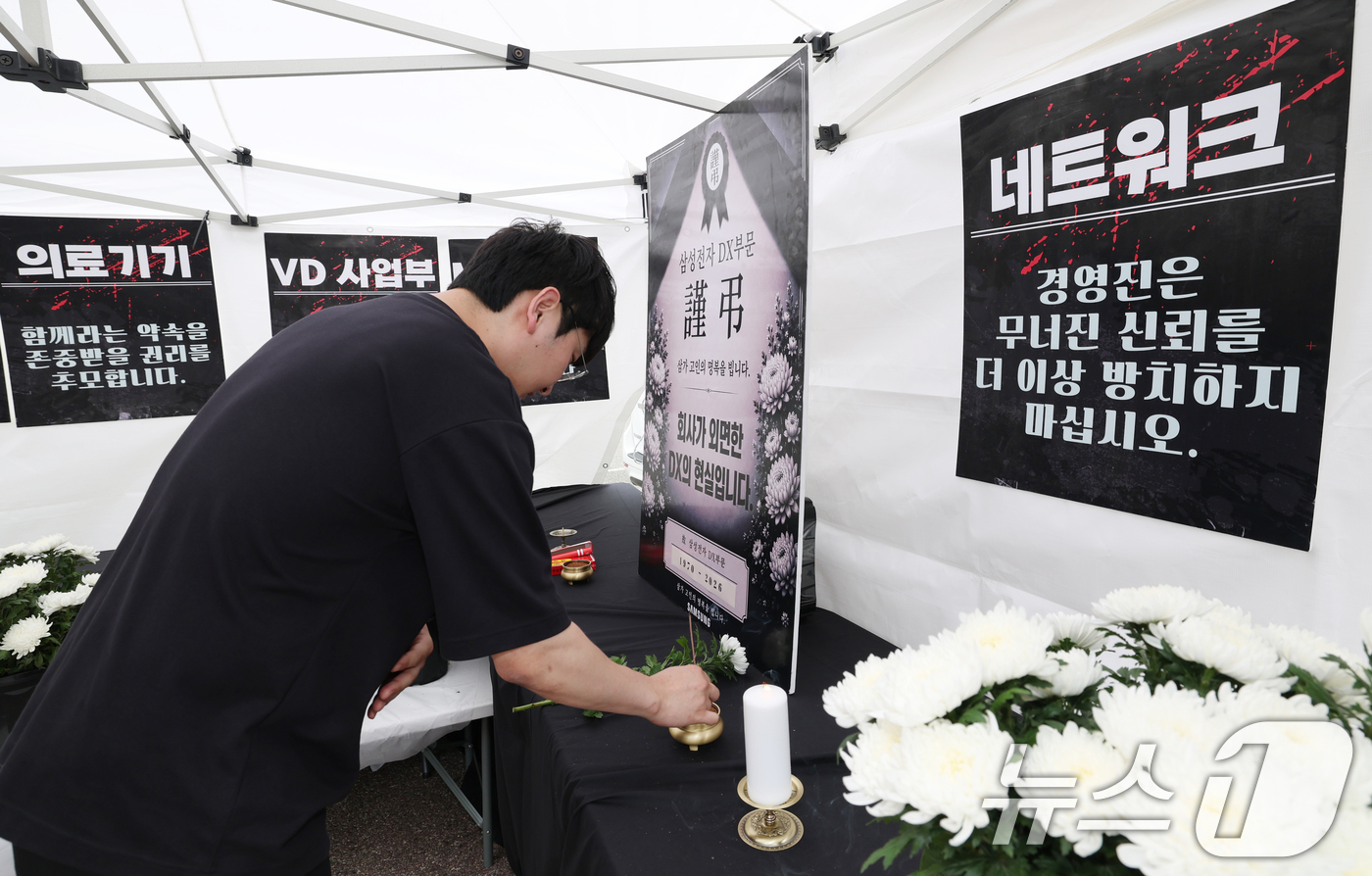 (수원=뉴스1) 김영운 기자 = 14일 경기 수원시 영통구 삼성전자 수원사업장 중앙문에서 열린 'DX부문 사기진작 및 보상마련 촉구 집회'에서 조합원들이 '2026 DX부문 사망선 …