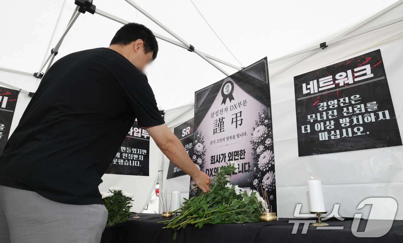 (수원=뉴스1) 김영운 기자 = 14일 경기 수원시 영통구 삼성전자 수원사업장 중앙문에서 열린 'DX부문 사기진작 및 보상마련 촉구 집회'에서 조합원들이 '2026 DX부문 사망선 …